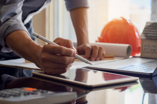 Architect with Tablet. Building Regulations for Extension Plans App on Laptop